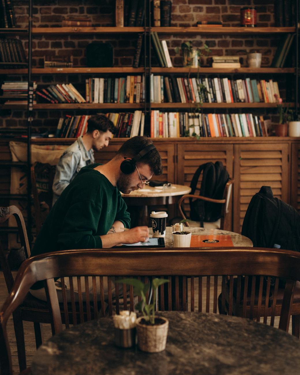 students sitting at coffee tables and making notes in library
